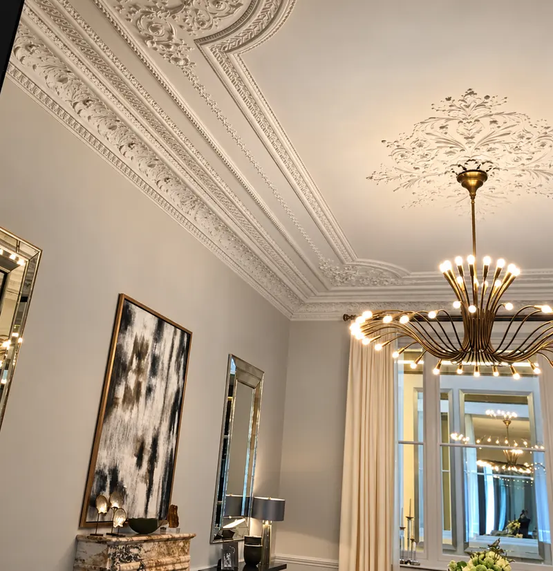 Brass chandelier beneath a restored ceiling rose