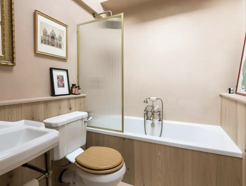 Bathroom with brass fittings and oak panelling